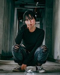 Portrait of woman sitting against wall