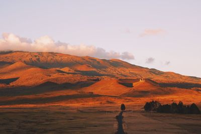 Landscape against mountains during sunset