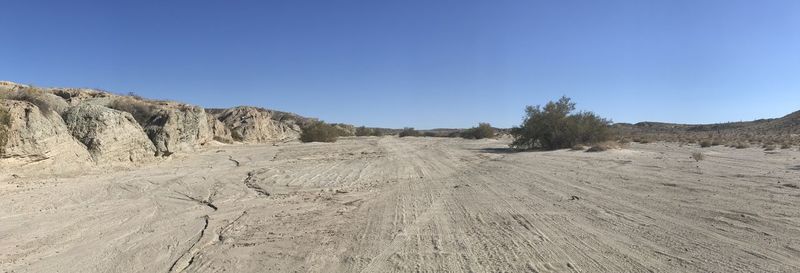 Scenic view of arid landscape against clear blue sky