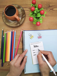 High angle view of hand holding book on table
