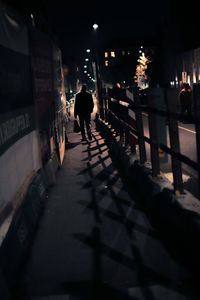 Man walking on illuminated city at night