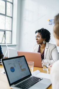 Business people with laptop computers at table in office