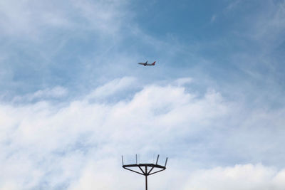 Low angle view of airplane in flight against sky