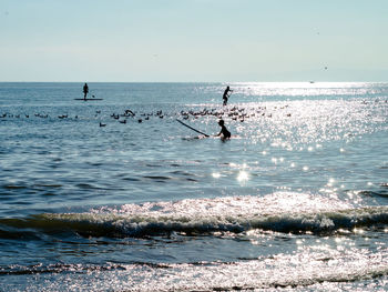 People on sea against sky