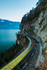 High angle view of road by sea against blue sky