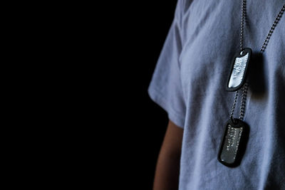 Close-up of man standing against black background