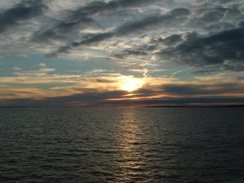 Scenic view of sea against cloudy sky at sunset