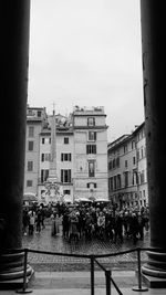 People on street against buildings in city