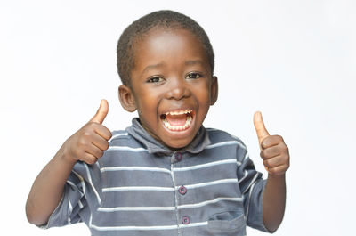 Portrait of smiling boy standing against white background