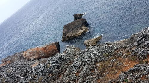 Rock formation on beach against sky