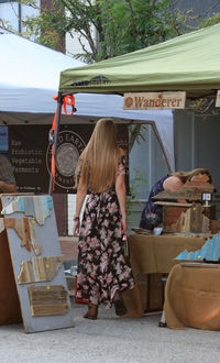 Rear view of woman standing at outdoor cafe