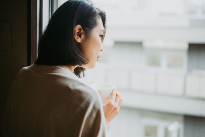 Portrait of young woman drinking coffee