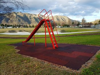 Playground in field against sky