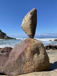 Rock formation on beach against clear sky