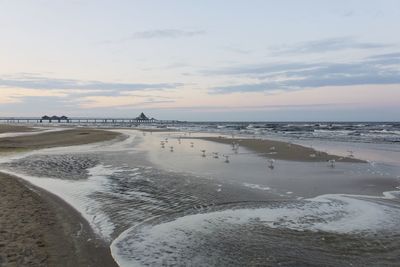 Scenic view of beach against sky during sunset