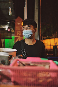 Portrait of young man standing in city at night