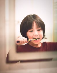 Close-up portrait of cute boy eating at home