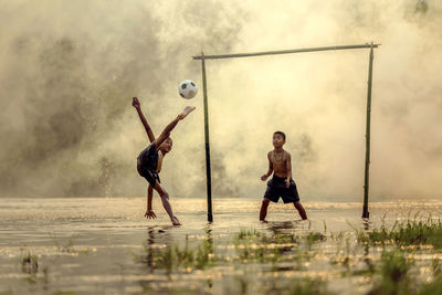 Boys playing football in water