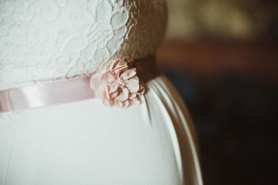 Close-up of woman wearing wedding dress with belt