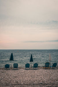 View of chairs on beach at sunset