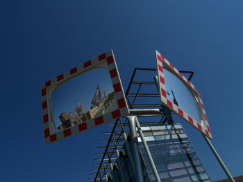 Low angle view of ferris wheel against clear blue sky