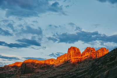 Rock formations on mountain against cloudy sky