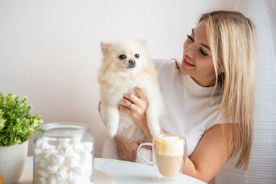 Portrait of woman with dog on table