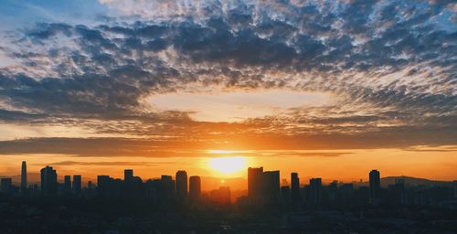 Scenic view of buildings against romantic sky at sunset