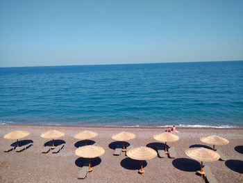 High angle view of parasols at beach against sky