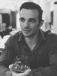 Close-up portrait of man holding drink at restaurant