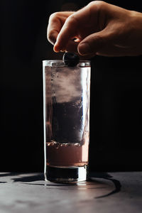 Close-up of hand holding drink in glass on table