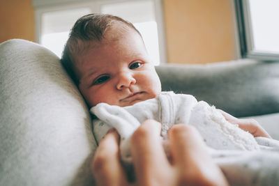 Portrait of cute baby lying on bed at home