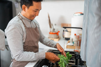 Side view of man preparing food at home