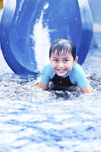 Portrait of smiling boy in water slide