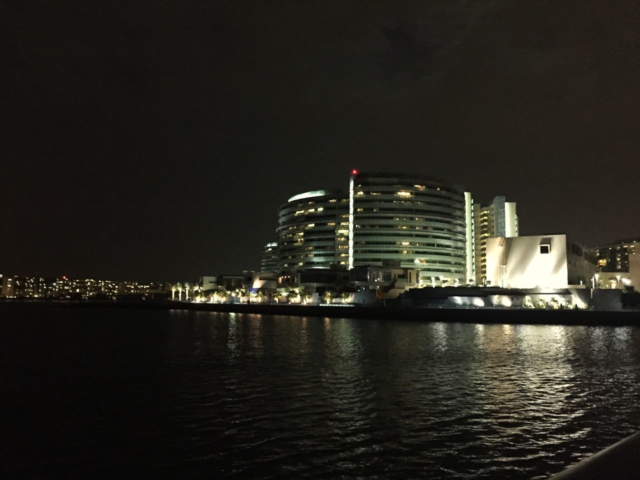 illuminated, building exterior, night, city, architecture, built structure, cityscape, water, waterfront, skyscraper, urban skyline, river, modern, office building, reflection, sky, sea, tower, tall - high, financial district