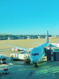 Airplane on airport runway against clear blue sky