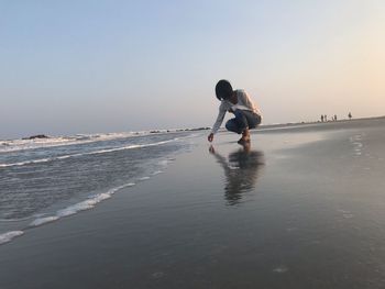 People on beach against clear sky