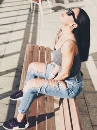 High angle view of woman using phone while standing on footpath