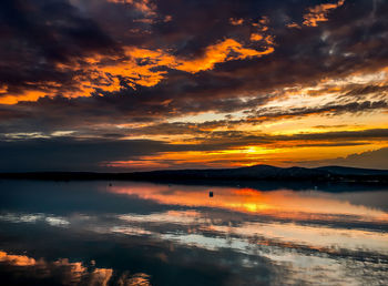 Scenic view of sea against dramatic sky during sunset