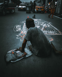 Rear view of people sitting on city street