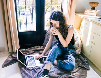 Young woman using mobile phone at home