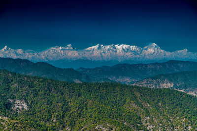 Scenic view of snowcapped mountains against clear blue sky