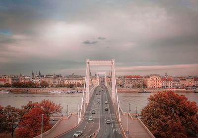 View of bridge over city against cloudy sky