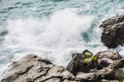 High angle view of waves splashing on rocks