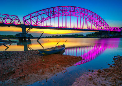 View of illuminated ferris wheel in river