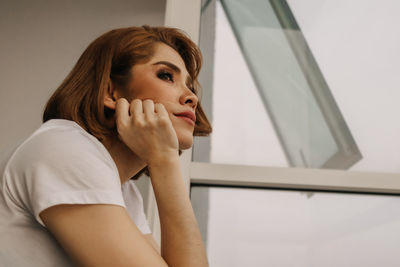 Portrait of young woman looking away at home