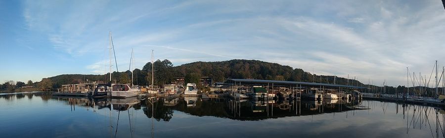 Sailboats moored in lake against sky