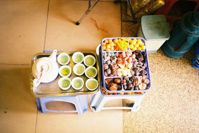 High angle view of green tea and dried fruits on stool