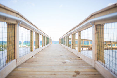 Empty footbridge against sky