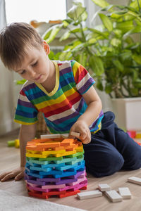 Boy playing with toy blocks on table